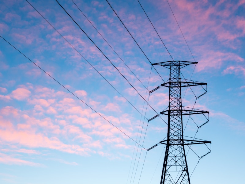 Pylône haute tension sous des nuages orangés